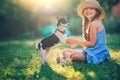 Happy girl playing with cute playful puppy little dog outdoor on a sunny day in a park