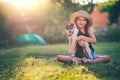 Happy girl playing with cute playful puppy little dog outdoor on a sunny day in a park Royalty Free Stock Photo