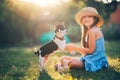 Happy girl playing with cute playful puppy little dog outdoor on a sunny day in a park Royalty Free Stock Photo