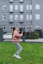 Happy girl playing with dog in her arms on a walk. The owner holds in her hands a little dog breed toy poodle, standing on the