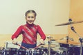 Happy girl playing the drums. Teen girls are having fun playing drum sets in music class. Girl in red drumming. toned Royalty Free Stock Photo