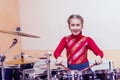 Happy girl playing the drums. Teen girls are having fun playing drum sets in music class. Girl in red drumming. toned Royalty Free Stock Photo