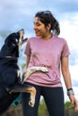 Happy girl playing with her dog on the grass. A cute dog kissing his owner in the field Royalty Free Stock Photo