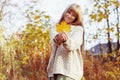 Happy girl playing with leaf, looking at camera and smilling. Autumn portrait woman hides her face yellow maple leaf Royalty Free Stock Photo