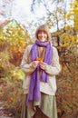 Happy girl playing with leaf, looking at camera and smilling. Autumn portrait woman hides her face yellow maple leaf Royalty Free Stock Photo