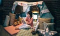 Happy girl playing with stuffed animal in a diy tent