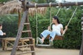 Happy girl playing on the wooden swing in the playground Royalty Free Stock Photo