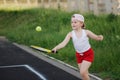 Happy girl plays tennis on court outdoors Royalty Free Stock Photo