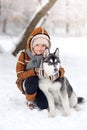 The happy girl plays in the winter wood with a dog Royalty Free Stock Photo