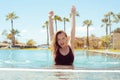 Happy girl in the pool, blonde with long hair in a red bathing suit. The girl rejoices in traveling, flirts, smiles, rejoices.