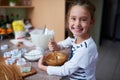 Happy girl, portrait and baking with bowl of dessert for cupcake mixture, caramel or cooking at home. Little child, kid Royalty Free Stock Photo