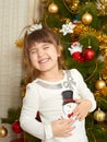 Happy girl portrait in christmas decoration, playing with snowman toy, winter holiday concept, decorated fir tree and gifts Royalty Free Stock Photo