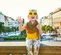 Happy girl in Prague in pineapple sunglasses handwaving