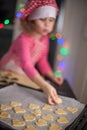 Happy girl preparing biscuits in the kitchen, casual lifestyle photo in real life interior, christmas cookies,kid in chef dress