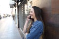 Happy girl profile talking on phone in the street