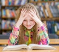 Happy girl reading a book in the library