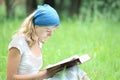 happy girl reading a book on the nature of the Bible in the Park Royalty Free Stock Photo