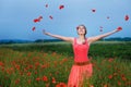 Happy girl in a red dress on poppy field Royalty Free Stock Photo