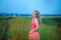 Happy girl in a red dress on poppy field Royalty Free Stock Photo