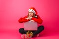 Happy girl in a red sweater and Santa hat, sitting with a laptop Royalty Free Stock Photo