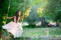 Happy girl rides on a swing in park. Little Princess has fun outdoor, summer nature outdoor. Childhood, child lifestyle, enjoyment