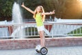 A pretty happy girl riding on hover boards or gyroscooters outdoors at sunset in summer. Active life concept