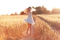 Happy girl on the road in a wheat field Royalty Free Stock Photo