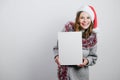 Happy young woman in Santa hat with blank empty canvas board. Mockup poster for Christmas message. Copy space. Royalty Free Stock Photo