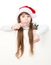 Happy girl in santa hat with Christmas candy cane standing behin behind banner. on white Royalty Free Stock Photo