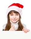 happy girl in santa hat with Christmas candy cane standing behind white board. isolated on white background Royalty Free Stock Photo