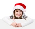 Happy girl in santa hat with Christmas candy cane standing behind white board. isolated on white background Royalty Free Stock Photo