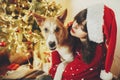 Happy girl in santa hat hugging with cute dog on background of g Royalty Free Stock Photo