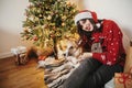 Happy girl in santa hat hugging with cute dog on background of g Royalty Free Stock Photo