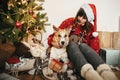 Happy girl in santa hat hugging with cute dog on background of g Royalty Free Stock Photo