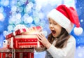 Happy Girl in Santa Hat Opening a Gift Box Royalty Free Stock Photo