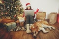 Happy girl in santa hat shopping online on laptop and sitting wi Royalty Free Stock Photo