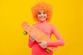 Happy girl scater with orange hair in pink poloneck smile holding pennyboard, skateboarding Royalty Free Stock Photo