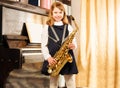 Happy girl in school uniform holds alto saxophone Royalty Free Stock Photo