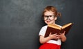 Happy girl schoolgirl with book from blackboard Royalty Free Stock Photo