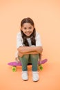 Happy girl sit on penny board on yellow background. Little child smile with long hair on skateboard. Beauty salon. Style Royalty Free Stock Photo