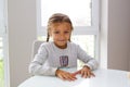 happy girl sitting at an empty white table in a new apartment Royalty Free Stock Photo