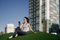 A happy girl is sitting on the green grass in the yard of her house Royalty Free Stock Photo