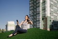 A happy girl is sitting on the green grass in the yard of her house Royalty Free Stock Photo