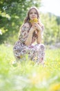 Happy girl with a small bouquet of first summer flowers