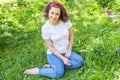 Happy girl smiling outdoor. Beautiful young brunete woman with brown hair resting on park or garden green grass background.