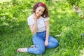 Happy girl smiling outdoor. Beautiful young brunete woman with brown hair resting on park or garden green grass background.