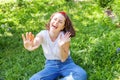 Happy girl smiling outdoor. Beautiful young brunete woman with brown hair resting on park or garden green grass