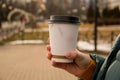 Happy girl smiling outdoor having lunch break. Beautiful young brunete woman with take away coffee cup resting on park or garden