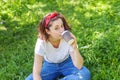 Happy girl smiling outdoor having lunch break. Beautiful young brunete woman with take away coffee cup resting on park or garden Royalty Free Stock Photo