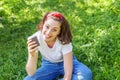 Happy girl smiling outdoor having lunch break. Beautiful young brunete woman with take away coffee cup resting on park or garden Royalty Free Stock Photo
